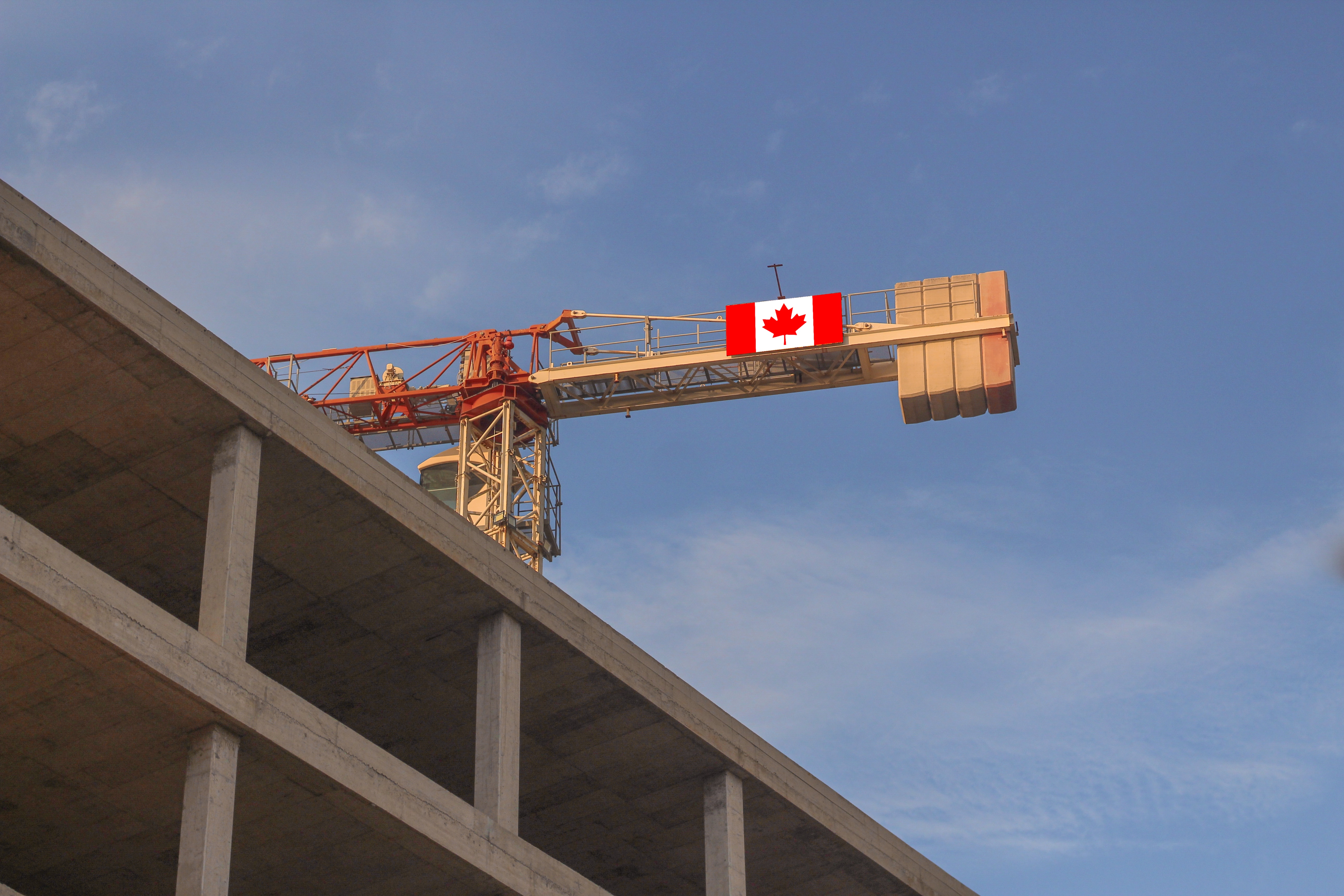 Chantier de construction avec une grue montrant le drapeau canadien